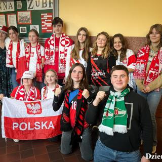 Uczniowie z gadżetami kibiców i flagą Polski