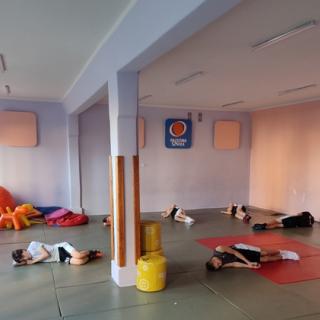 Uczniowie leżą wygodnie na materacach i wykonują ćwiczenia relaksacyjne - trening progresywnej relaksacji mięśni metodą Jacobsona