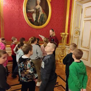 Uczniowie oglądający obraz w sali Zamku Królewskiego.