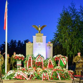 Pomnik Żołnierzy 1920 roku w Markach. Przed pomnikiem złożone wieńce i asysta dwóch żołnierzy.
