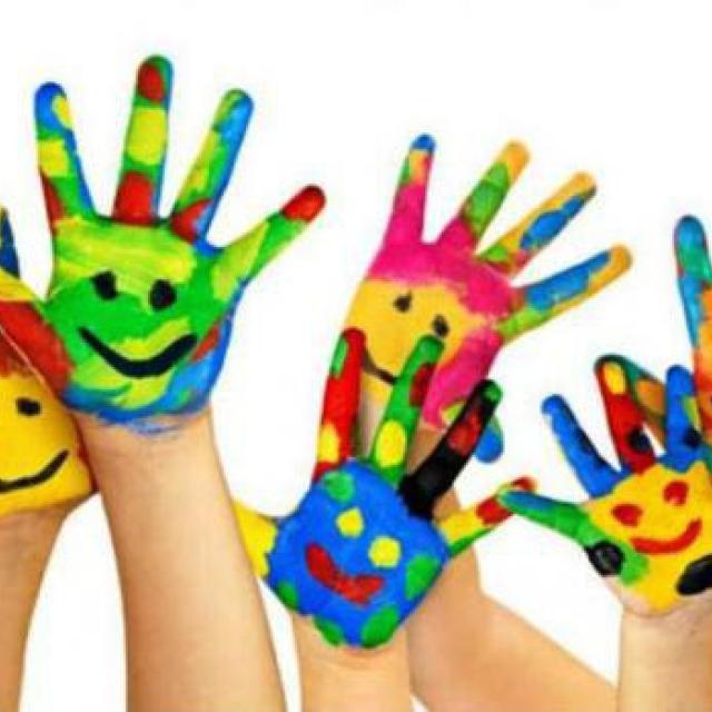 Ręce dzieci z namalowanymi wesołymi buziami