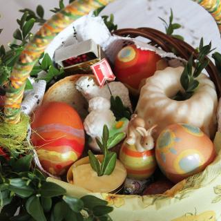 Koszyczek wielkanocny, a w nim: jajka, babka, baranek, chleb. Całość przystrojona zielonymi gałązkami bukszpanu.