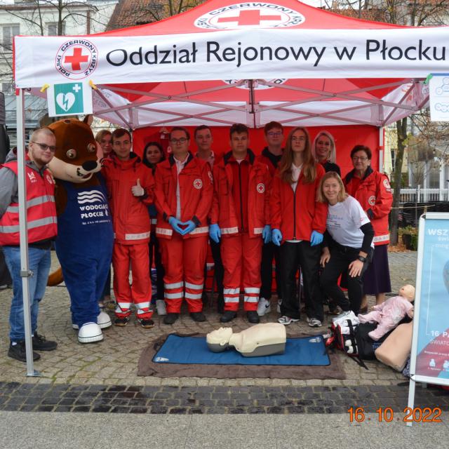 Widać Wolontariuszy Pck oraz Instruktorów Pierwszej Pomocy pod namiotem  Odziałowu Rejonowego PCK w Płocku oraz phantoma