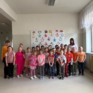 Uczniowie i nauczyciele ubrani na różowo i pomarańczowo.