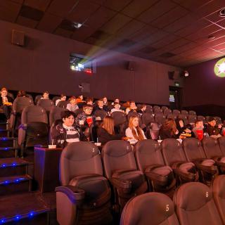 Uczniowie klasy 8 i 7 siedzą w sali kinowej podczas projekcji filmu