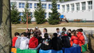 Grupa uczniów na tle budynku szkoły