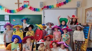 uczniowie w kolorowych kapeluszach z bibuły
